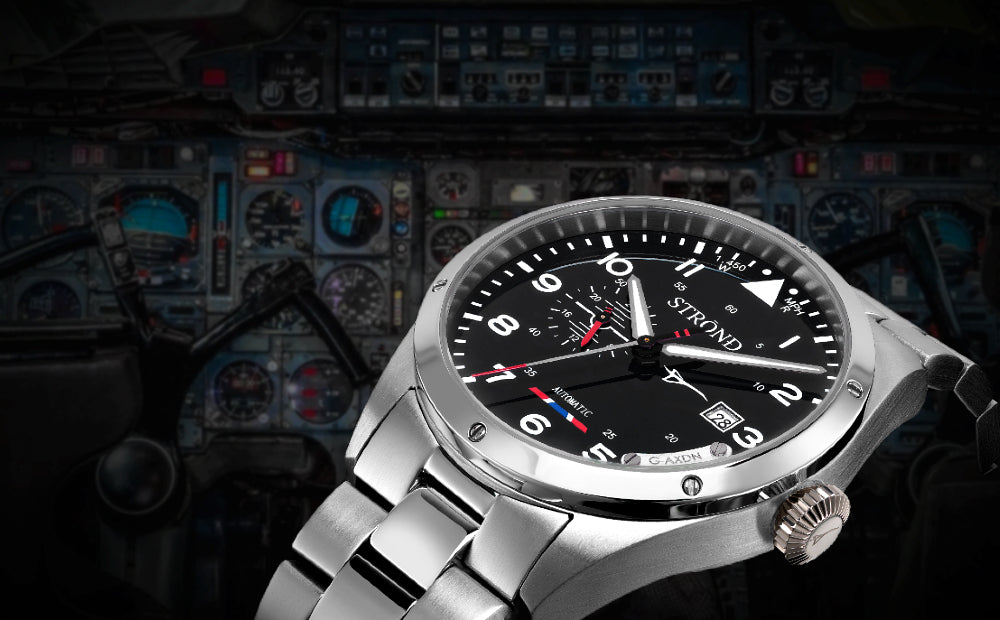 Silver watch with black dial on a background of aircraft instruments