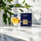 "Guerlain Shalimar 3 oz Eau de Parfum Spray – elegant glass bottle with golden-hued fragrance and iconic fan-shaped blue stopper, presented alongside its classic packaging."​